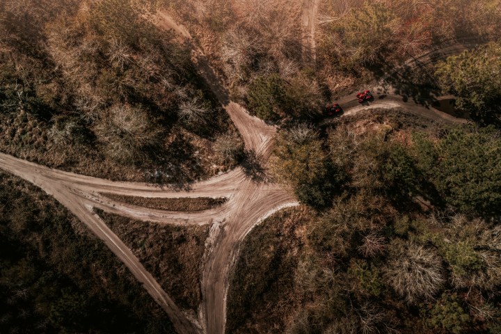 Aerial view of a dirt road intersection in a forested area.