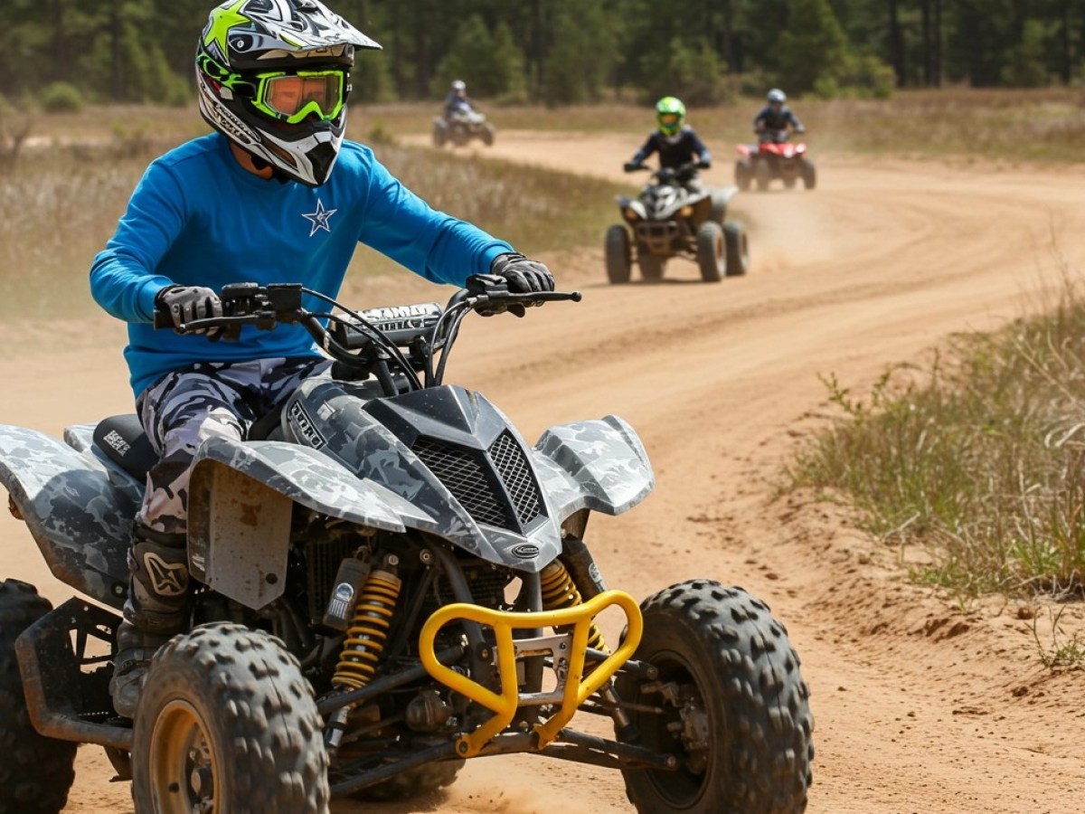 People riding ATVs on a dirt track, wearing helmets and protective gear.
